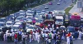 BJP activists shout anti-UPA government slogans as they block traffic near Akshardham Mandir in east Delhi during a protest against the petrol price hike on Monday