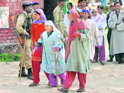 An elderly woman being assisted towards a polling station at Chak Dara village on the outskirts of Srinagar on Monday.