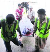Volunteers carry the bullet-riddled body of the Saudi diplomat into a hospital in Karachi on Monday