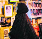 A woman looks at pictures of those killed or missing since the uprising against Gaddafis rule. 