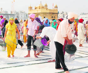 With intense heat waves engulfing the region, devotees pour water to cool the marble slabs in the Golden Temple in Amritsar.