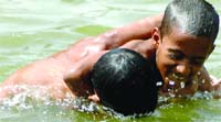 Boys play in the water to cool themseleves at Boat Club in New Delhi 