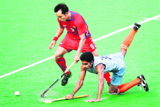 South Korea's Yooon Sung-hoon (in red) fights for the ball with India's Vikas Sharma during Azlan Shah Cup in Ipoh. India ended 6th in the tournament.