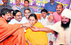 Chief Minister Ramesh Pokhriyal Nishank and saints offer a glass of juice to Uma Bharti to end her fast on Wednesday