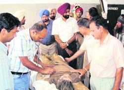 Doctors examine a landslide victim at a civil hospital in Jagraon