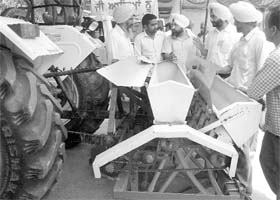 FARM TECH Farmers take a look at a paddy sowing machine during the Kisan Mela at Phase VII in Mohali on Thursday
