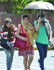 Girls protect themselves from heat as the temperature soared above 42 C in New Delhi on Thursday.
