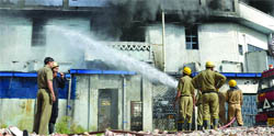 Delhi fire service personnel extinguish fire at a printing press in Patparganj, East Delhi, on Thursday. 