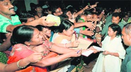Trinamool supremo Mamata Banerjee gives autographs to people at her Kalighat residence in Kolkata on Thursday.