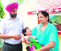 Deputy Commissioner Kahan Singh Pannu and his wife hold the baby girl left in the pangura at Red Cross Bhawan in Amritsar. 