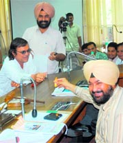 Disappointed Opposition councillor Gurcharan Dass Kala (extreme left), flanked by Jagjit Singh Kang, offers a lollipop to Mayor Ravinder Pal Singh (right) during a General House meeting at the MCs office in Sector 17, Chandigarh