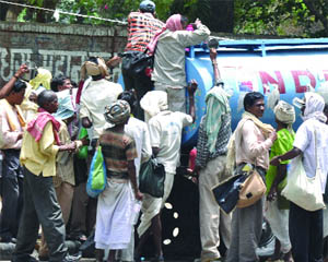 People try to fill water from a tanker in New Delhi