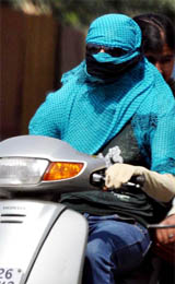 A young girl covers herself on a hot Friday in Gurgaon