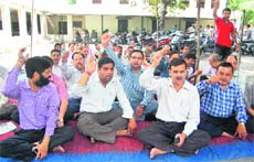 Collectorate employees hold a dharna in Dehradun on Friday.