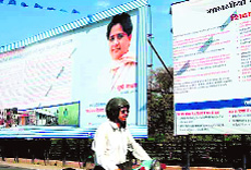 A scooterist rides past a hoarding on Mayawati in Haridwar