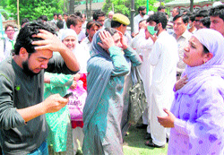 Relatives of Shaker Ahmad Bhat, a Class X student, who was feared drowned in the Jhelum, wail in Srinagar on Friday