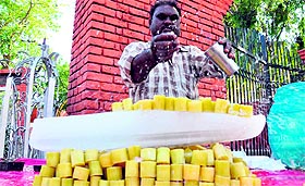 Making the most of hot weather, a vendor sells sliced sugarcane in Jammu.