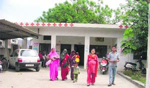 People wait for medicines at a dispensary in Sunet