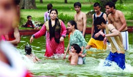 Delhiites enjoy themselves as the temperature dips after the morning showers at India Gate in New Delhi on Saturday.