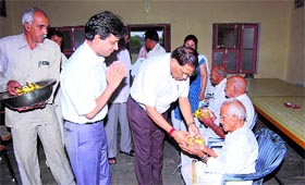 District and Sessions Judge Shiva Sharma distributes fruits among senior citizens in Sirsa on Saturday.