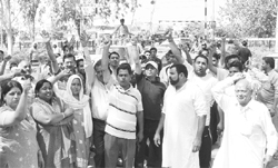 Residents block the link road near level crossing at Sector 19, Panchkula, on Sunday.