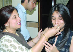 Mother of Urmi Uppal, the Delhi topper from Delhi Public School, Mathura Road, feeds her sweets.