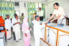 Deputy Commissioner Ashok Sagwan distributes bank drafts among beneficiaries under the marriage scheme in Yamunanagar on Monday.