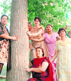 Dr Navjot Kaur Sidhu and members of the Art of Living Foundation embrace a tree in Amritsar on Monday.