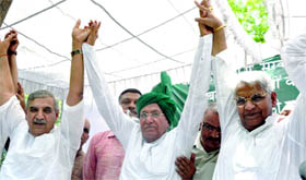 Om Prakash Chautala, president of the Indian National Lok Dal, joins hands with his party leaders during a rally against price hike and the alleged grabbing of farmers lands in New Delhi on Tuesday.