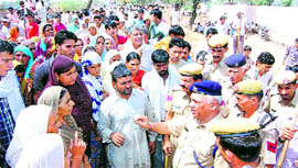 A police officer tries to pacify villagers blocking traffic near Mangala village in Sirsa on Tuesday.