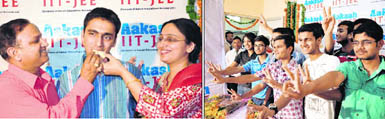 The parents of Raghav Gupta, who secured the 74th all-India rank in the IIT-JEE, offer sweets to him in Dehradun on Wednesday; (right) Successful candidates in the IIT-JEE in a happy mood in Dehradun 
