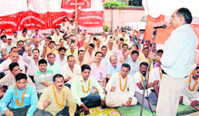 Employees of the Uttarakhand Forest Corporation hold a dharna in Dehradun 