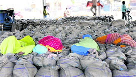 Women workers take a nap on wheat bags at the New Grain Market in Karnal.