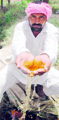 A farmer shows polluted water in his palms