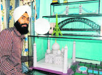 Gurpreet Singh shows his paper replicas of the Taj Mahal and Eifel Tower in Amritsar.