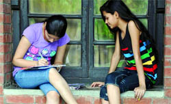 Aspirants fill in admission forms at St. Stephens College in New Delhi on Friday.