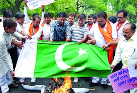 Activists of the Shiv Sena burn an effigy of Pakistani Prime Minister Yousuf Raza Gilani and the Pakistani flag to protest against the country for sheltering terrorists, in New Delhi on Friday.