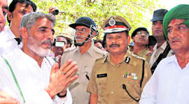 Balbir Singh, alias Bali Pehalwan (left), a former INLD MLA from Meham, surrenders before Rohtak range IGP V Kamaraja at the latter's office in Rohtak on Friday.