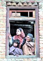 Members of a family watch the funeral of a militant, Qari Zubair, and his accomplice at Keller village on the outskirts of Srinagar on Friday