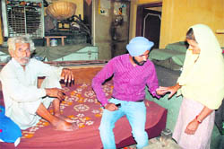 Gurmeet Singh Bajwa looks at the fractured finger of an elderly woman at Kang village in RS Pura