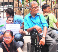 Disabled rights group activists hold placards to protest against the non-implementation of the 11th Plan in New Delhi on Friday
