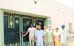 Residents of Dyalpura Bhaika in front of Devinder Singh Bhullars locked house. 