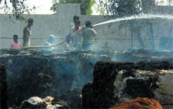The fire brigade personnel extinguishing fire at the yarn manufacturing factory near Jalalabad on Sunday