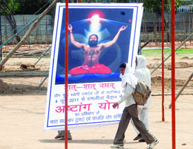 Labourers fix a hoarding at Ramlila Grounds for the Astha Yoga Camp and satyagrah against corruption beginning on June 4 by the yoga guru Ramdev in New Delhi on Sunday.
