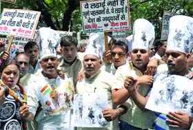 Delhi BJP activists hold placards and shout slogans against the Delhi government in New Delhi on Monday