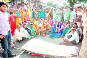 Residents of Nayagaon village place the body of Sonu, who was murdered, on a road near Dehradun on Monday