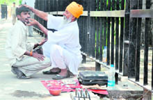 A quack outside the Mini-Secretariat treats a patient in Ludhiana. 