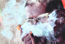 A resident takes a puff from a chilam on the eve of No Tobacco Day in Ludhiana on Monday. 