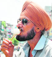 An aged man enjoys an ice candy in Amritsar