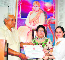 Kiranjit Kaur (center) presents a certificate to a student of Indian Council of Astrological Science at DAV College in Amritsar